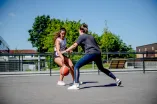 Zwei Studentinnen spielen draußen Basketball